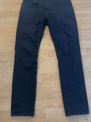 157 jeans - Snygga svarta slim fit jeans med klassisk femficksdesign och raka ben. Jeansen har en enkel look utan synliga loggor eller slitningar, vilket gör dem lätta att matcha med olika stilar. Tillverkade i ett mjukt och stretchigt material för extra komfort. Iprincip nya då den endast e använda typ 3 gånger!!
