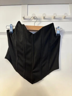 Svart formad korsett - Snygg svart korsett med markerade sömmar och spetsig nederkant