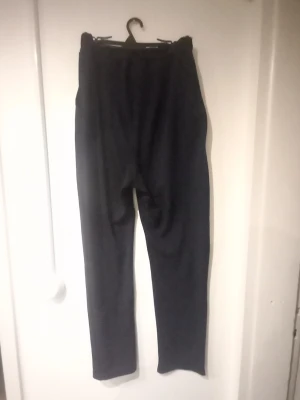 Svarta mjukisbyxor med rak passform - Säljer ett par svarta mjukisbyxor med rak passform och resår i midjan. Perfekta för chill dagar hemma eller när du vill ha det extra bekvämt. Tillverkade i mjukt material som känns skönt mot huden. Enkla att matcha med hoodie eller t-shirt.