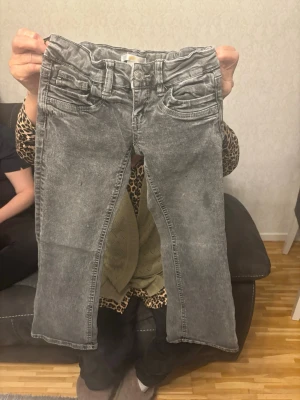 Grå low ways jeans  - Säljer ett par grå jeans med tvättad look och raka ben. Jeansen har klassisk femficksdesign, bälteshällor och knappgylf. Materialet är troligtvis bomull med stretch för extra komfort. Perfekta för en avslappnad och trendig stil. Köpte den förra veckan men de råka skicka mig fel storlek så jag säljer de här byxorna