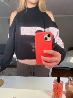 Svart stickad tröja med cut out axlar - Trendig svart stickad tröja med höghals och cut out-detaljer vid axlarna. Jag klippt ärmarna själv och den är från hm i storlek M💕
