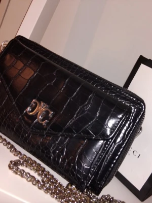 Oanvänd väska - Fin oanvänd väska. Med kedje så man kan ha den över axeln eller ta bort och använda som kuvertväska, super snyggt! 