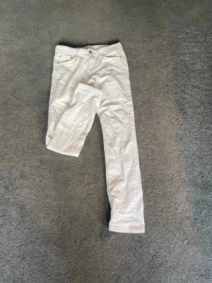 Vita slim fit jeans Jack & Jones - Säljer ett par vita slim fit jeans från Jack & Jones, modell Slim Glenn. Klassisk femficksdesign, raka ben och snygga detaljer i metall. Perfekta för dig som vill ha en clean och fräsch look till vardags eller när du vill sticka ut lite extra. ALLA FLÄCKARNA HAR BLIVIT BORTTVÄTTADE!!!