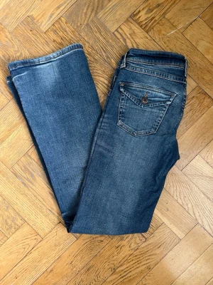 Blå bootcut jeans med pocket - Säljer ett par klassiska blå bootcut jeans med pocket i bra skick