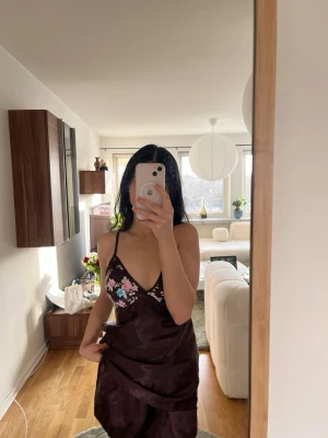 Mörklila nattset med blommigt mönster - Fint nattset i satin som består av linne, shorts morgonrock och långbyxor. Köpt utomlands. Endast använt 2–3 gånger. Säljs eftersom den är lite för stor för mig. Passar bäst för storlek M. I mycket fint skick.