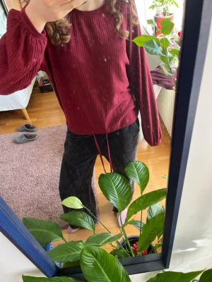 Vinröd ribbad tröja med ballongärm - Säljer en vinröd ribbad tröja med rund hals. Tröjan har dragsko i midjan för justerbar passform och är gjord i ett mjukt, stretchigt tyg. Perfekt för dig som gillar en avslappnad men trendig stil. Superskön och fin ❤️😜