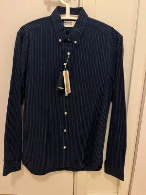 NY oanvänd skjorta från Dobber - Snygg mörkblå skjorta från Dobber. Ny och oanvänd med etiketter kvar. Storlek small.