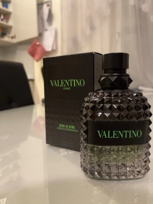 Valentino Uomo Born in Roma parfym - Snygg parfymflaska från Valentino, Uomo Born in Roma Green Stravaganza. Flaskan är transparent med svart och grönt, har ett coolt nitat mönster och svart lock. Kommer med originalkartong som matchar flaskans design. Skulle säga att det är runt 98ml kvar i den då den har aldrig använts! Tveka knte att höra av er vid frågor eller funderingar🤗