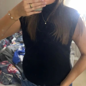 Svart ärmlös stickad topp - Svart ärmlös stickad topp med rund halsringning. Enkel och stilren design som passar perfekt till jeans eller kjol. Mjuk och skön känsla tack vare det stickade materialet. Endast använd en gång💞