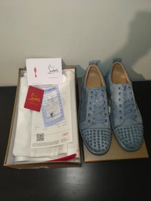 Blåa Christian Louboutin sneakers - Snygga blå sneakers från Christian Louboutin i mocka med matchande blå skosnören och coola nitar på tån. Skorna har en klassisk låg siluett och exklusiv känsla, perfekt för dig som vill sticka ut med stil. Kommer med originalkartong och tillbehör. Kvitto tillkommer, fastpris 