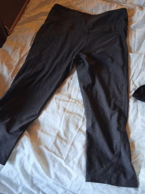 Mörkgrå korta träningsbyxor💕 - Säljer ett par mörkgrå leggings. De har hög midja och är tillverkade i ett mjukt stretchigt material som sitter skönt på kroppen. Perfekta för en avslappnad och trendig look.