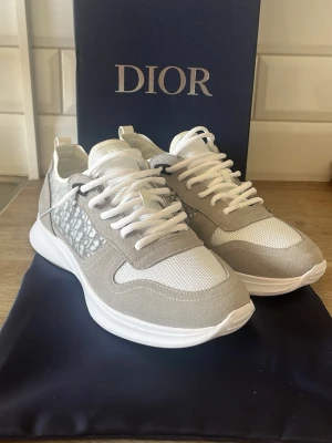 Dior B25 Grå - Snygga Gråa Dior B25 skor som är perfekt för våren och sommaren när man vill ha en ljus outfit. Dustbag och Box ingår                                                                      Aldrig använda!                                                 Fraktas oftast samma dag!