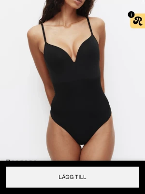 Svart shaping-body med bygel - Snygg svart shaping-body från H&M med tunna justerbara axelband och vadderade kupor med bygel. Djup urringning framtill och slät, figurnära passform. Perfekt under tighta plagg för en smickrande siluett. Materialet är stretchigt och bekvämt.