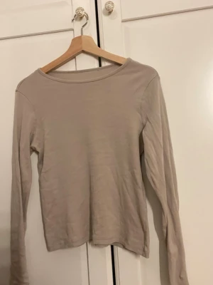 Beige långärmad topp från lager 157 - En enkel och stilren beige långärmad topp med rund hals. Perfekt att matcha med jeans den är från lager 157 men lappen är bortklippt 