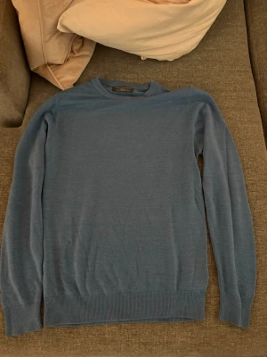 Blå rundhalsad tröja från Primark - En stilren blå tröja från Primark med rund halsringning och långa ärmar. Tröjan har ribbade muddar vid ärmslut och nederkant, vilket ger en snygg passform. Perfekt för dig som gillar enkel och klassisk stil.