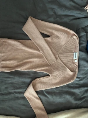 Beige ribbstickad tröja Kappahl  - Säljer en beige ribbstickad tröja från Kappahl med lång ärm och rund halsringning. Tröjan är figurnära och har en mjuk, stretchig känsla som passar perfekt till jeans eller kjol. Enkel och stilren design som är lätt att matcha. 