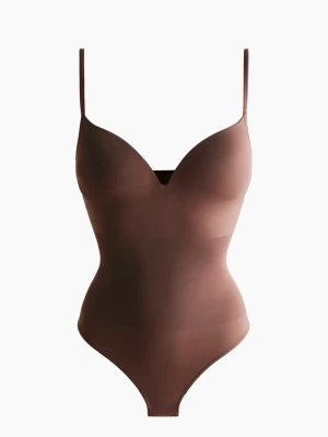 Brun shaping body från H&M - Snygg brun shaping body från H&M med tunna, justerbara axelband och vadderade kupor. Bodyn har en djup urringning och är tillverkad i ett stretchigt, slätt material som formar kroppen. Utsåld! 🫶🏻