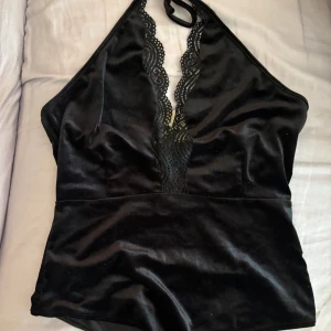 Svart body Bik Bok - Snygg svart body i sammet från Bik Bok. Halterneck-modell som knyts i nacken och ger en elegant siluett. Är endast provat, prislapp kvar. 