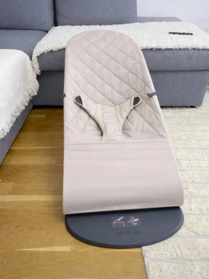 Beige babysitter från BabyBjörn - Säljer en stilren babysitter från BabyBjörn i beige quiltat tyg. Babysittern har en mjuk sits, säkerhetssele och svart stabil bas. Perfekt för att underhålla och lugna små barn hemma.