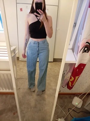 Ljusblåa raka jeans - Säljer ett par ljusblåa jeans med rak passform. Jeansen har klassisk knappstängning och fickor både fram och bak. Materialet är denim och de är perfekta för en avslappnad och trendig look.