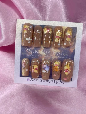 SweetPooh (XS);Medium Square;Curved - Supergulliga handgjorda press-on naglar i brun nyans med motiv av Nalle Puh och vänner. Naglarna har en glansig finish och dekoreras med söta detaljer som ballonger, blommor och citat. Perfekt för dig som vill ha något unikt och lekfullt på naglarna.