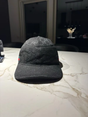 Svart Gucci keps - Säljer denna keps eftersom jag fick en annan keps och jag inte har en användning av den här. Kepsen är i väldigt bra skick inga skador, kepsen är one size. Pris går att diskutera vid snabb affär.