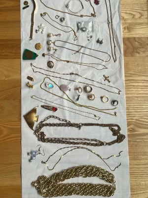 Stort smyckespaket med blandade accessoarer - Säljer ett stort paket med blandade smycken, inklusive halsband, ringar, örhängen och armband i olika stilar. Färgerna är främst guld, silver och några inslag av färgade stenar. Materialen varierar mellan metall, pärlor och plast. Perfekt för dig som vill mixa och matcha accessoarer.Bara 350kr