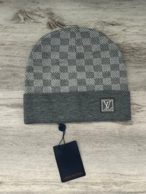 Grå mössa med rutmönster - Snygg grå mössa med klassiskt rutmönster och vikt kant. logga på framsidan och diskret etikett. Tillverkad i mjukt material som känns lyxigt och bekvämt. Perfekt accessoar för att lyfta din stil.