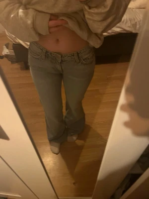 Weekday Ljusblå bootcut jeans med låg midja - Säljer ett par ljusblå bootcut jeans med låg midja och klassiska fem fickor. Jeansen har en avslappnad passform och är perfekta för en trendig vardagslook. Materialet är denim och färgen är en snygg tvättad blå nyans. Helt nya, och aldrig använda 