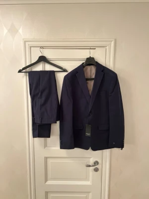 Oanvänd Lawrence Grey 50 kostym marinblå nypris 4000kr - Säljer en stilren och elegant marinblå kostym från Lawrence Grey.  Nypris: ca 4 000 kr Mitt pris: 1 695 kr  Helt ny och aldrig använd, i perfekt skick. Storlek: 50  Tidlös och välsittande modell – perfekt för student, examen, bröllop, bal eller jobb där ett professionellt intryck är viktigt. En klassisk marinblå kostym som fungerar året runt.  Kan fraktas eller provas i Sollentuna. Har även fler kostymer i andra storlekar och märken. Hör av dig vid intresse!