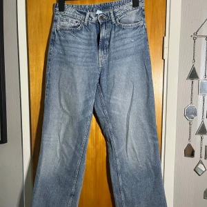  jeans straight fit - Jeans i ljusblå tvätt med rak passform. Jeansen har fem fickor, knappgylf och en snygg vintage look. Perfekta för dig som gillar tidlös denimstil och vill ha ett par jeans som funkar till allt.