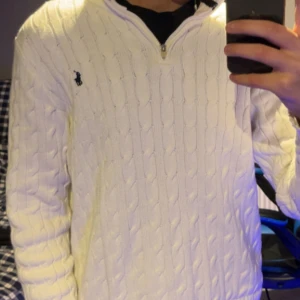 Vit kabelstickad tröja Polo Ralph Lauren - Vit kabelstickad tröja från Polo Ralph Lauren med half zip. Den är riktigt stilig och passar till allt! Köpt i butik på rea för 2000 men ny pris ca 2600. Tröjan är i storlek S och har inga slitningar eller defekter.