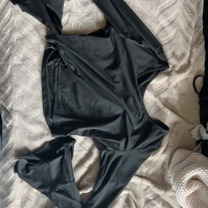 Svart långärmad topp från SHEIN -  Svart  långärmad topp från SHEIN i stretchigt och mjukt material. Volang som går ut vid händerna 