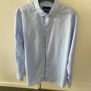 Ljusblå skjorta från Massimo Dutti - Snygg ljusblå skjorta från Massimo Dutti i storlek M, modellen är ca 180 cm lång. Hör av dig vid funderingar!