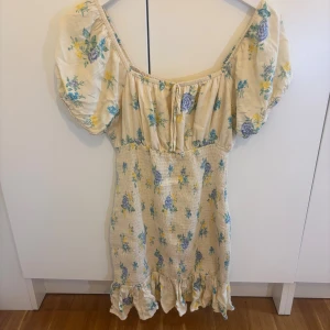 En gul sommar klänning med blommor - Passar fint och den är perfekt att ha ute till sommaren och våren