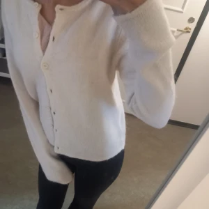 Vit kofta från Gina Tricot - Mysig vit kofta från Gina Tricot i premiumkvalitet. Koftan har rund halsringning, långa ärmar och knäppning framtill med små knappar. Perfekt att ta på sig när det är lite kyligare ute, perfekt nu för hösten. Pris kan diskuteras.