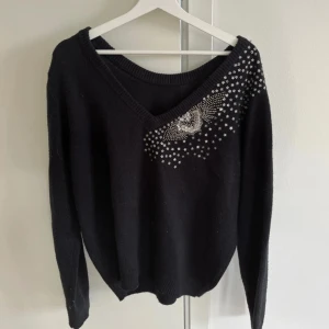 Stickad tröja med paljetter - Stickad tröja med silvriga paljetter i strl M/L. Bra skick!