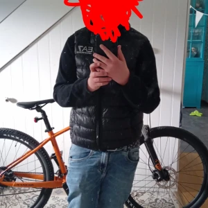 Svart dunväst från Emporio Armani EA7 - Snygg svart dunväst från Emporio Armani EA7 med quiltad design och diskret logga på bröstet. Västen är lätt och smidig, perfekt att slänga över en hoodie eller tröja. Klassisk passform och stilren look som funkar till det mesta. Inte använt så mycket det står storlek smål på västen så ni vet 