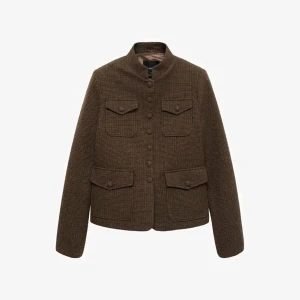 SØKER!!! Brun kavajjacka med fickor - Stilren brun kavajjacka med fyra fickor framtill och knappar hela vägen upp till den höga kragen. Jackan har en klassisk, rak passform och är tillverkad i ett ulligt material med diskret rutmönster. Perfekt för dig som gillar en tidlös look.