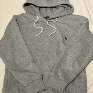Grå Ralph Lauren hoodie - Säljer nu denna gråa Ralph Lauren hoodie då den inte passade. Fint skick på den utan täcken på användning. Hör gärna av vid fler funderingar!