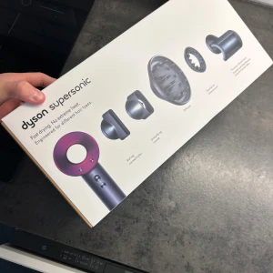 Dyson Supersonic HD07 - Dyson Supersonic HD07 hårfön med flera munstycken för styling, snabb torkning och skydd mot extrem värme. Komplett med originaltillbehör och kartong, i mycket gott skick. Perfekt för alla hårtyper. Inga synliga defekter eller slitage.