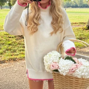 Vit stickad tröja med rosa kant - Superfin vit stickad tröja från Meet Me There med ribbade muddar och detaljer i rosa längs hals, ärmslut och nederkant. Tröjan har en loose passform och långa ärmar, perfekt för lager på lager under höst och vår. Det är helt nytt men det passade inte mig.