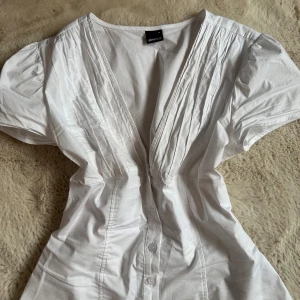 Vit blus med v-ringning och knappar - Snygg vit blus! Från Gina men helt slutsåld🌸Endast använd en gång
