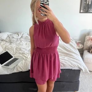 Smockad klänning med hög hals - Säljer denna snygga armlösa klänning med hög hals och smockad midja❤️En perfekt cocktail eller festklänning💗 