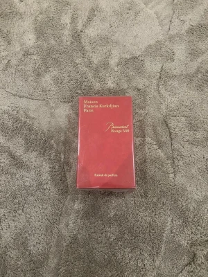 Baccarat Rouge 540 parfym - Maison Francis Kurkdjian Baccarat Rouge 540 Extrait de Parfum i en elegant röd kartong med guldtext. Lyxig och ikonisk doft som kommer i en rektangulär förpackning. Perfekt för dig som gillar exklusiva parfymer.