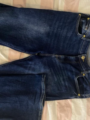 Mörkblå flared jeans från Bershka - Snygga mörkblå jeans från Bershka med flared ben och klassisk femficksdesign. Jeansen är tillverkade i ett slitstarkt bomullsjeanstyg. Pris kan diskuteras!😍 Använda typ 2 gånger så de är i stort sätt i nytt skick! Storlek 40/M