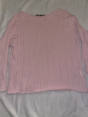 Ljusrosa stickad tröja med hålmönster - Söt ljusrosa stickad tröja med lång ärm och diskret hålmönster i vertikala rader. Från Lager 157