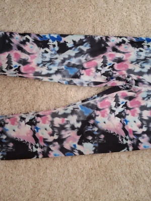 Mönstrade leggings från Iconic - Säljer ett par färgglada leggings från Iconic i storlek S. De har ett abstrakt mönster i svart, rosa, blått och vitt. Helt nya och aldrig använda med lappen kvar. Säljes för de inte används.