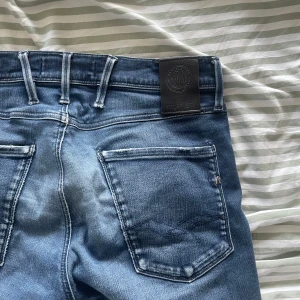 Replay Anbass Hyperflex jeans blå - Säljer ett par Replay Anbass Hyperflex jeans i klassisk blå tvätt. Jeansen har fem fickor och smal passform. Stretchigt material för extra komfort och cool Replay-detalj på myntfickan. Perfekta för dig som gillar stilrena och bekväma jeans. Storlek w31. Har du någon fråga är det bara att höra av dig mvh Levi!