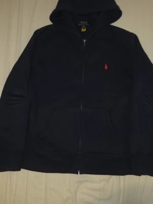 Stilren ralph lauren mörk blå tröja - Äkta ralph lauren tröja, ny pris 1300kr. Säljer eftersom den har blivit för liten, den är änvänd ett få tal gånger. Den är i storleken 150cm/ 10-12 åringar. KAN GÅ NER I PRIS!